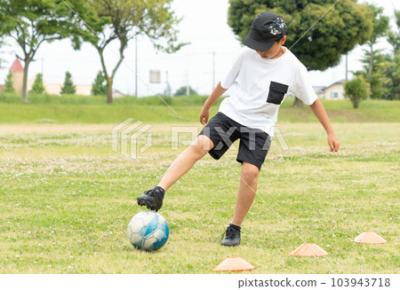 Asian kid playing soccer in the park 103943718
