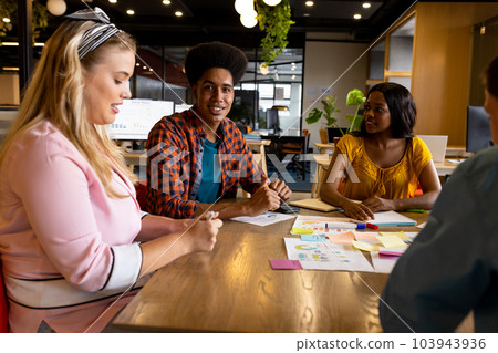 Diverse creative colleagues in discussion brainstorming using tablet and notes in office Diverse creative colleagues in discussion brainstorming using tablet and notes in office 103943936