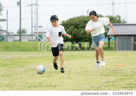 Asian kid playing soccer in the park Asian kid playing soccer in the park 103943974