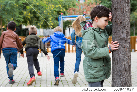 Boy playing hide and seek with children Boy playing hide and seek with children 103944057