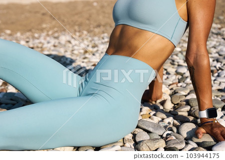 Fitness woman using training ropes for sports, on the beach at sunrise. Exercising by the sea 103944175
