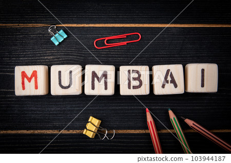 MUMBAI a large city in India. Word from alphabet blocks on a dark textured wooden background. Close MUMBAI a large city in India. Word from alphabet blocks on a dark textured wooden background. Close 103944187