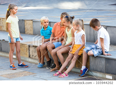 Cheerful boys and girls playing charades Cheerful boys and girls playing charades 103944202