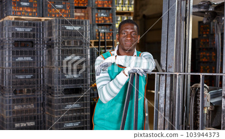 Adult African worker and electric lift truck Adult African worker and electric lift truck 103944373