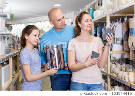 Loving parents and happy girl shopping for bathroom accessories at store of home decor 103944419