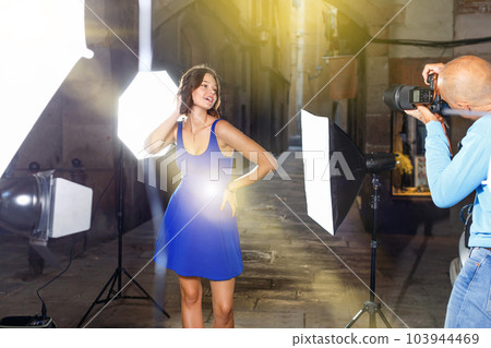 Professional photo shooting outdoors. Attractive female model po 103944469