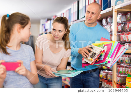 Parents trying to draw daughter attention to school supplies Parents trying to draw daughter attention to school supplies 103944495