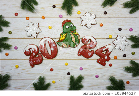 Gingerbread figures 2024 are laid out on a wooden table Gingerbread figures 2024 are laid out on a wooden table 103944527