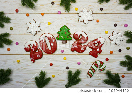 Gingerbread figures 2024 are laid out on a wooden table 103944530