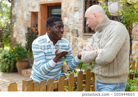 Disgruntled men talking in backyard Disgruntled men talking in backyard 103944603