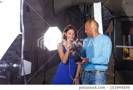 successful photographer and model discussing picture on camera display on city street successful photographer and model discussing picture on camera display on city street 103944899