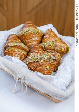croissants in a wicker basket on a white table 103945215