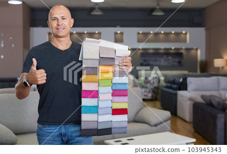 Sales consultant demonstrating samples of upholstery fabric Sales consultant demonstrating samples of upholstery fabric 103945343