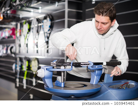 Nice man is correcting tennis rackets 103945401