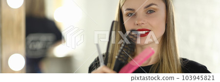 Portrait of woman hairdresser holding combs and scissors 103945821