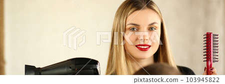 Woman hairdresser is holding hair dryer and comb man is sitting in chair Woman hairdresser is holding hair dryer and comb man is sitting in chair 103945822