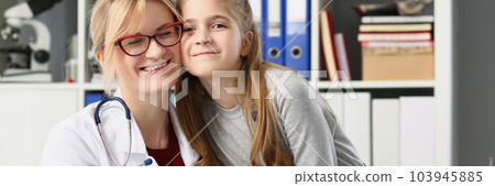 Smiling doctor and baby girl together in clinic Smiling doctor and baby girl together in clinic 103945885