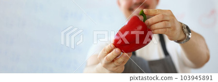 Smiling male cook holding red peppers closeup 103945891