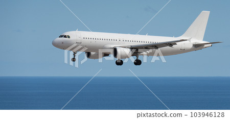 Airplane landing above ocean. Passenger aircraft. Business commercial. Landing to airport next to the beach. Airplane flies extremely low over the sea beach Airplane landing above ocean. Passenger aircraft. Business commercial. Landing to airport next to the beach. Airplane flies extremely low over the sea beach 103946128