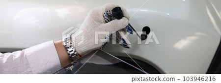 Auto mechanic holds tablet and car tube on white auto 103946216