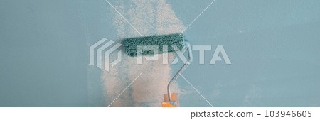Hand painting the wall with decorator roller and painting walls 103946605