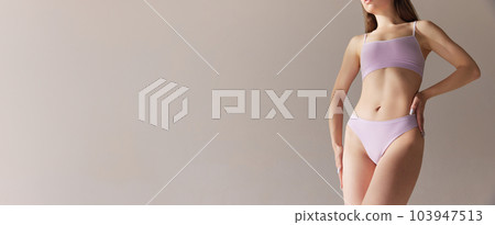 Cropped image of slim female body, breast, belly, buttocks in underwear against grey studio background. Banner 103947513