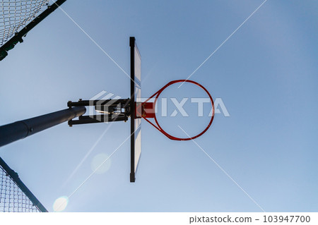 Bottom view of a basketball hoop outdoor. Blue sky as background and copy space. Urban street sport game 103947700