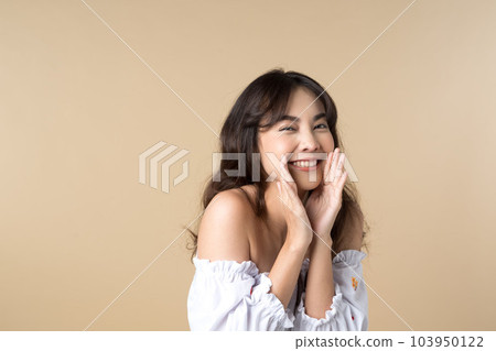 Young Asian woman doing a shocked surprise gesture shouting with hands cupped around mouth isolated brown color background 103950122