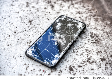 一部屏幕破裂的智能手機從摩托車上掉了下來 103950297