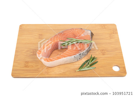 Portion steak from red fish, salmon, trout, on a cutting board with rosemary sprigs. Portion steak from red fish, salmon, trout, on a cutting board with rosemary sprigs. 103951721