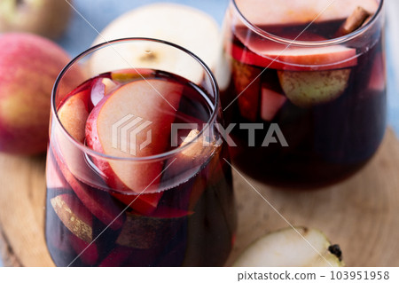 Autumn sangria with pear and apple on blue background Autumn sangria with pear and apple on blue background 103951958