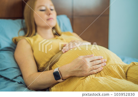A stressed tired pregnant mother lying in bed at home. Morning sickness and nausea A stressed tired pregnant mother lying in bed at home. Morning sickness and nausea 103952830