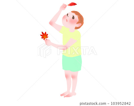 穿著黃色短袖T恤和短褲的赤腳男孩在陽光下看著秋葉和落葉 103952842
