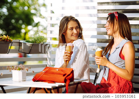 Two young female friends having fun and eating ice cream. Young women enjoy summer and vacation. 103953161