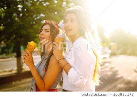 Two young female friends having fun and eating ice cream. Young women enjoy summer and vacation. 103953172