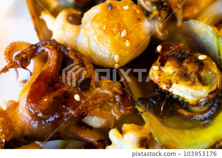 Grilled Galician octopus leg with sauce on plate in restaurant close up Grilled Galician octopus leg with sauce on plate in restaurant close up 103953176