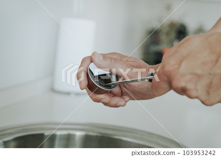 man emptying a used coffee capsule 103953242