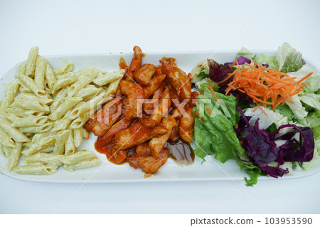 cooked pasta. chicken and salad on a plate on table . cooked pasta. chicken and salad on a plate on table . 103953590