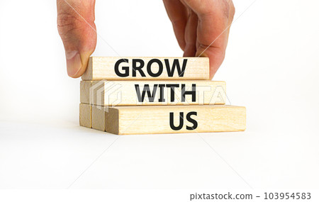 Grow with us symbol. Concept words Grow with us on wooden blocks on a beautiful white table white background. Businessman hand. Business, motivational and grow with us concept. Copy space. 103954583