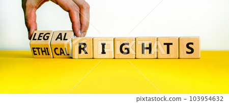 Ethical or legal rights symbol. Businessman turns wooden cubes and changes words ethical rights to legal rights on a beautiful white background. Business, ethical or legal rights concept. Copy space. 103954632