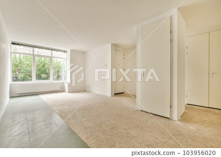 an empty room with white walls and floorboards on the wall, there is no one in the room to be seen 103956020