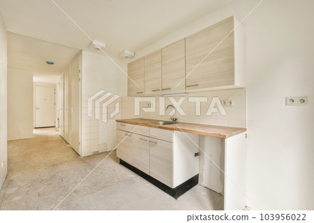 an unfinished kitchen with white cabinets and wood counter tops on the floor in a room that is being used for storage 103956022