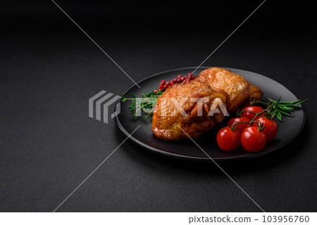 Delicious juicy chicken thighs baked with salt, spices and herbs in a ceramic plate 103956760