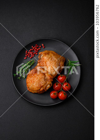 Delicious juicy chicken thighs baked with salt, spices and herbs in a ceramic plate 103956762