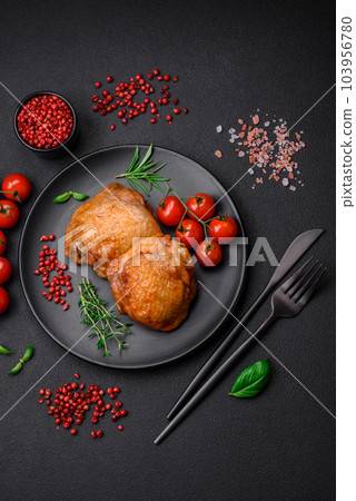 Delicious juicy chicken thighs baked with salt, spices and herbs in a ceramic plate Delicious juicy chicken thighs baked with salt, spices and herbs in a ceramic plate 103956780