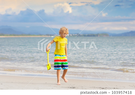 Kids play on tropical beach. Sand and water toy. Kids play on tropical beach. Sand and water toy. 103957418