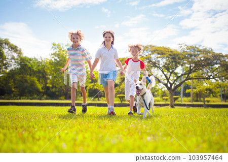 Kids play with dog. Children and puppy run in park Kids play with dog. Children and puppy run in park 103957464