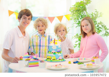 Kids birthday party. Child blowing out cake candle Kids birthday party. Child blowing out cake candle 103957472