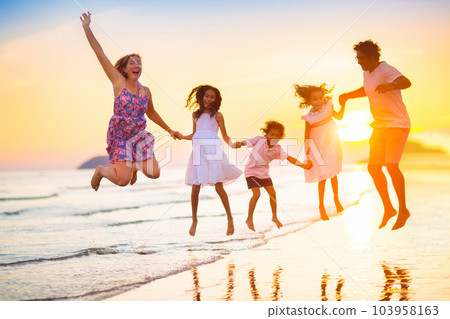 Family walking on tropical beach at sunset 103958163