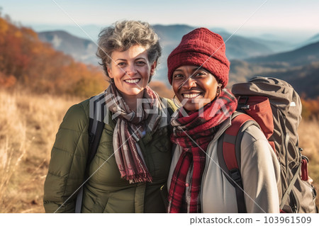 Active middle aged interracial lespian couple hiking, winter sunshine outdoors. Generative AI 103961509